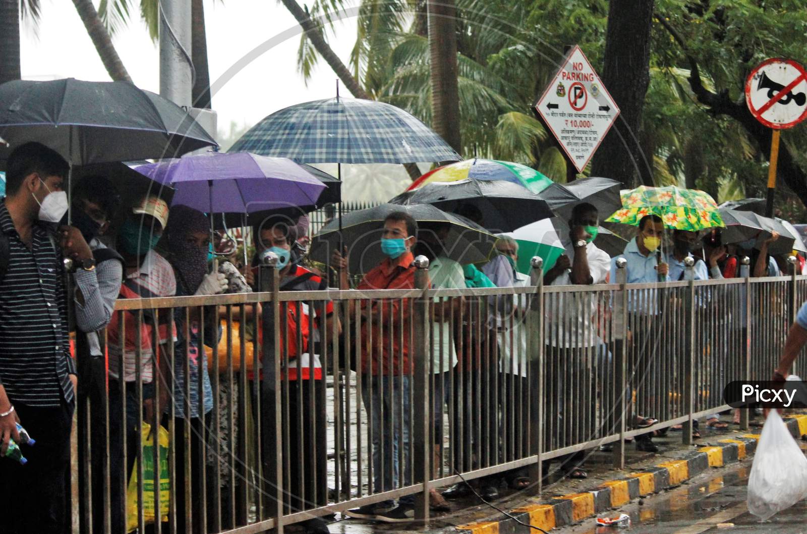 People wait to board a public bus during heavy rains, in Mumbai, India on July 4, 2020.