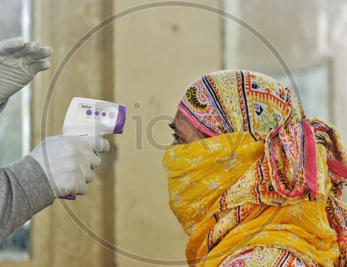 A healthcare worker checks the temperature of a resident during a medical campaign for the coronavirus disease (COVID-19), in Mumbai, India, July 1, 2020.