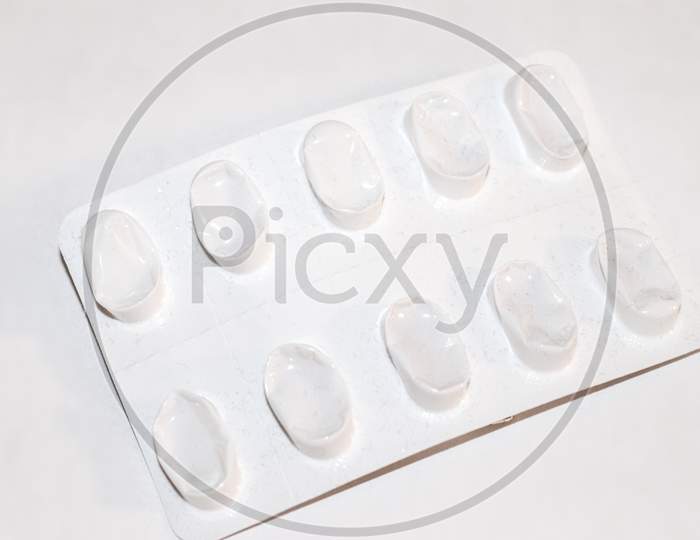 Pharmacy Drugstore Concept. Packs Of White Pills Packed In Blisters With Copy Space Isolated On A White Background. Focus On Foreground, Soft Bokeh.
