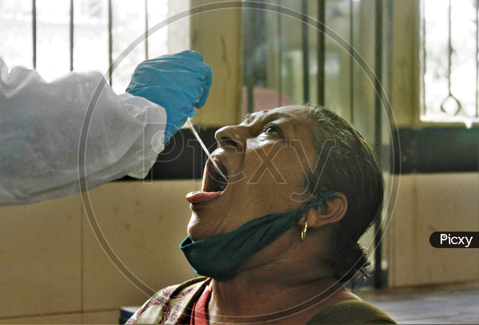 A healthcare worker collects a swab sample from a resident during a check-up campaign for the coronavirus disease (COVID-19), in Mumbai, India on July 1, 2020.