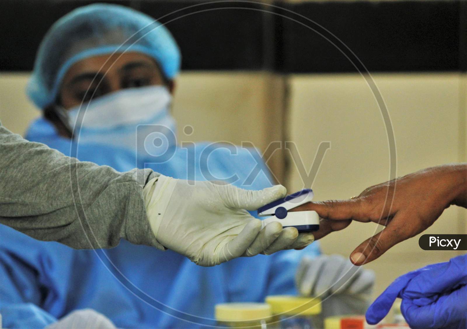 A healthcare worker checks the pulse of a resident during a medical campaign for the coronavirus disease (COVID-19), in Mumbai, India, July 1, 2020