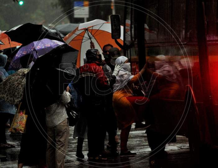 A woman boards a public bus during heavy rains, in Mumbai, India on July 4, 2020.