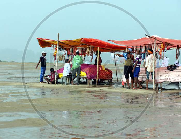 People walking under a heavy downpour on the banks of River Ganga in Prayagraj, Uttar Pradesh on July 6, 2020