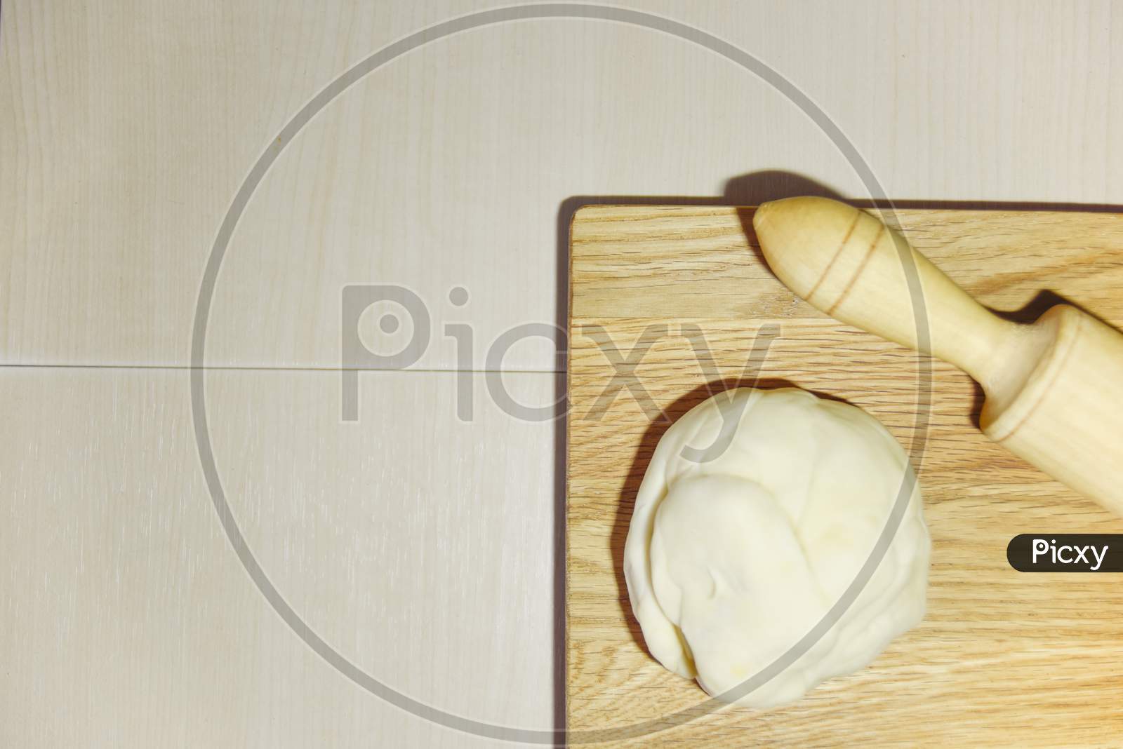 Focus On The Chopping Board And Blury Dough And Roller. Cooking Concept