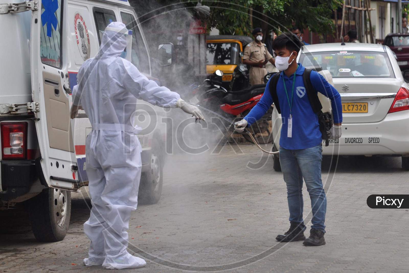 A health worker sprays disinfectant on another health worker outside a Covid-19 test collection center outside a hospital in Guwahati, Assam on July 06, 2020.