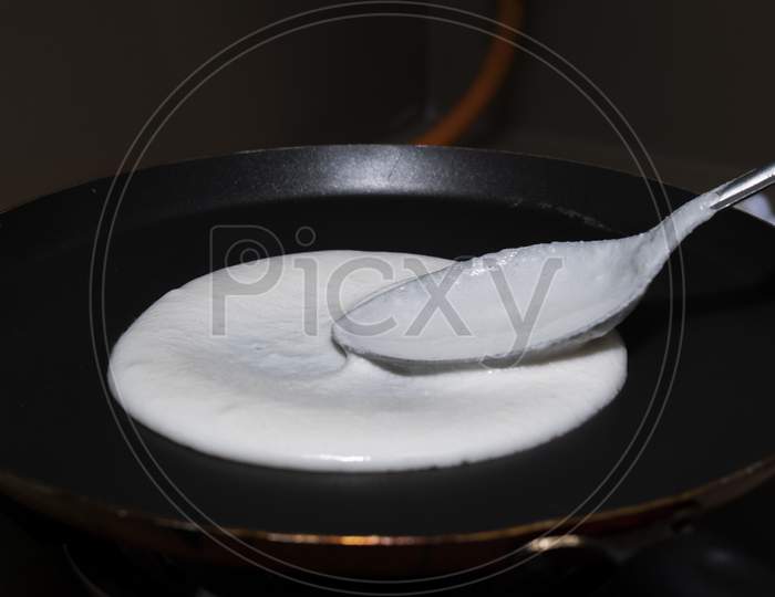 Spreading Dosa Or Idli Batter On Non Stick Tawa With Spoon For Making Delicious Round Dosa