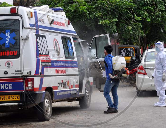A health worker sprays disinfectant on an ambulance outside a government hospital in Guwahati, Assam on July 06, 2020.