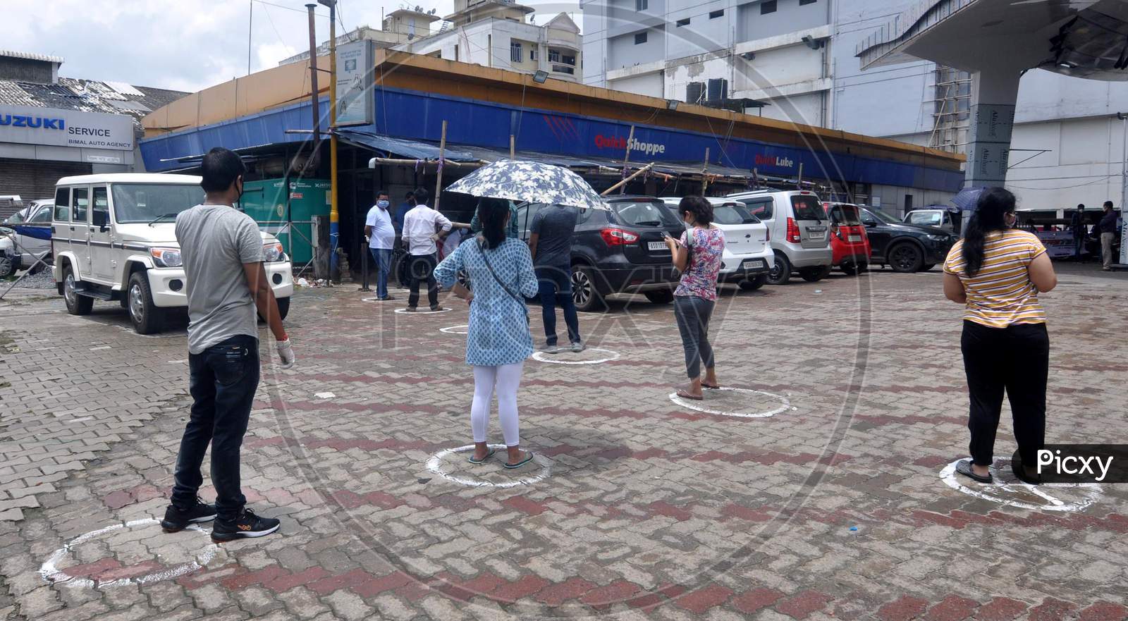 People maintain social distance as they stand outside a grocery shops after the government eases lockdown in Guwahati, Assam on July 06, 2020.