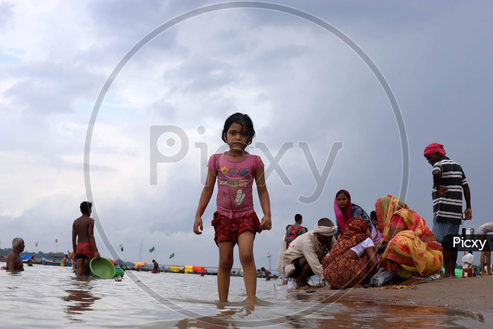 A kid stands ashore of River Ganga which witnessed an increase in its water level due to heavy rainfall in Prayagraj, Uttar Pradesh on July 07, 2020