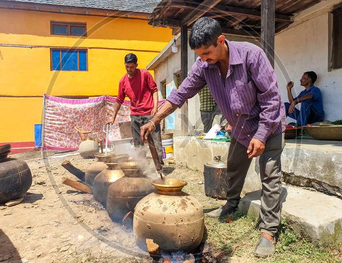 Mandi, Himachal Pradesh / India - June 15 2020: Photo of Indian people making Indian food in marriage in big pot in outdoor during lockdown days, himachal pradesh, India