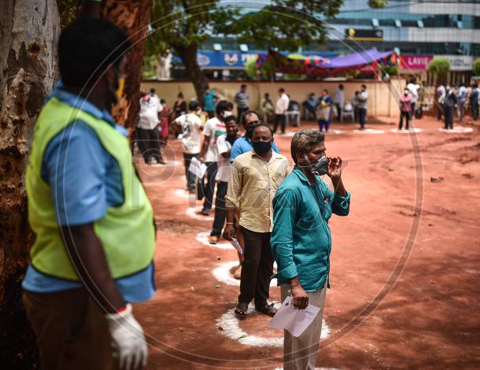 People wait in a queue for the COVID-19 test in Vijayawada.