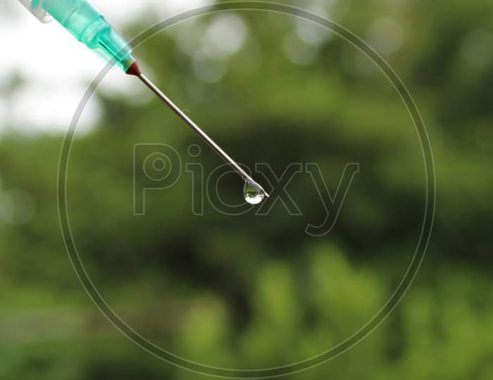 Syringe with water drop photo capture