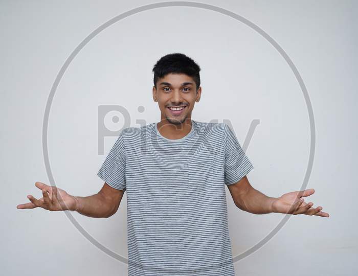 Young Asian Teen Boy Confused Expression With A Smile Showing To The Camera With White Background.