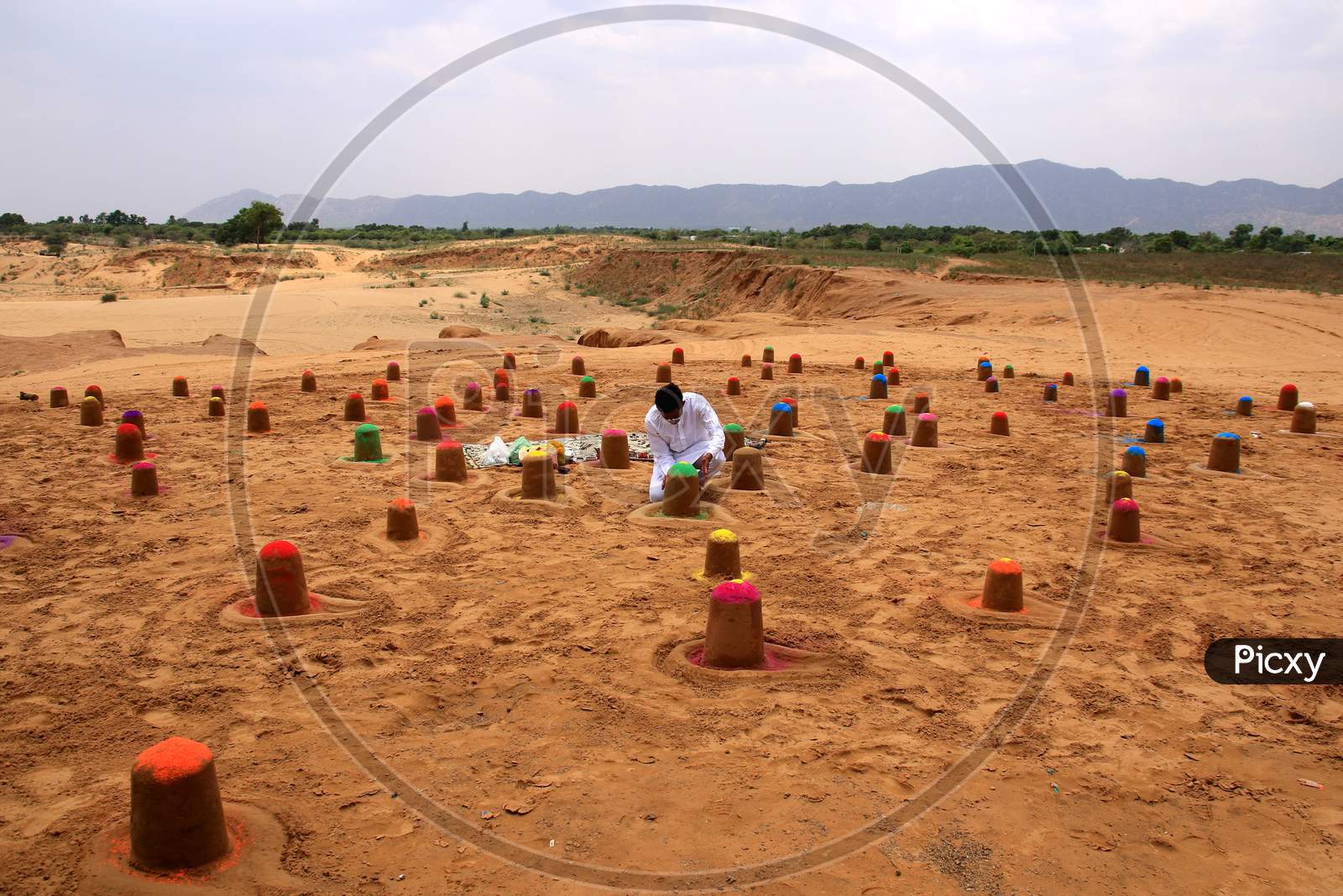 Indian sand artist Ajay Rawat creates 108 shivalings on the first Monday of 'Sawan'month in Pushkar, Rajasthan on July 06, 2020.