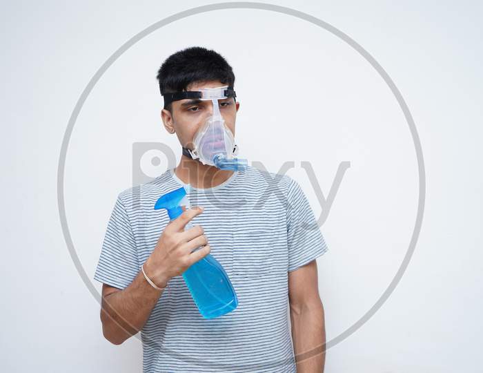 Young Asian Teen Boy Using Sanitizer While Wearing Oxygen Mask.