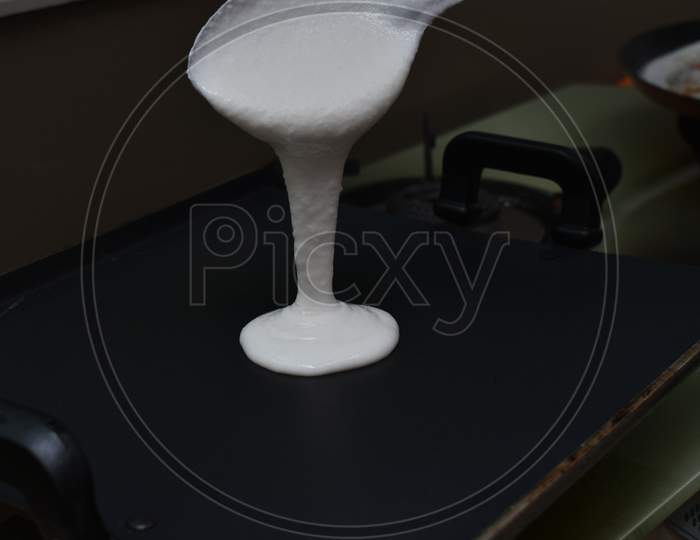 Pouring White Dosa Batter On Hot Non Stick Pan Or Tawa With Spoon
