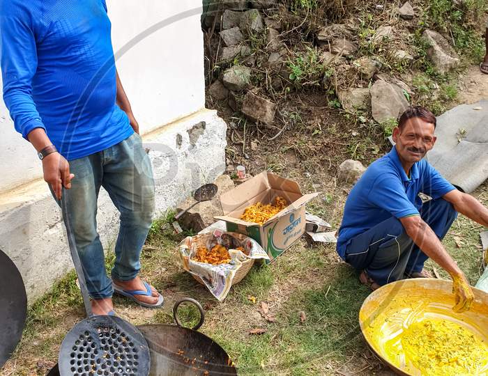 Mandi, Himachal Pradesh / India - June 15 2020: Photo of Indian people making Indian snacks (pakora) in outdoor during lockdown with selective focus, selective focus on subject, background blur