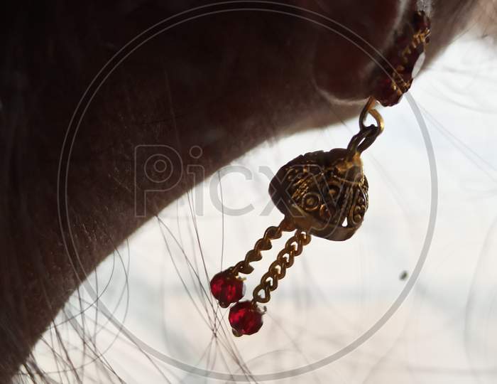 Closeup shot of ear of an Indian lady wearing ear jewellery,Close-Up Of Woman With bell Shape Ear jewellery.