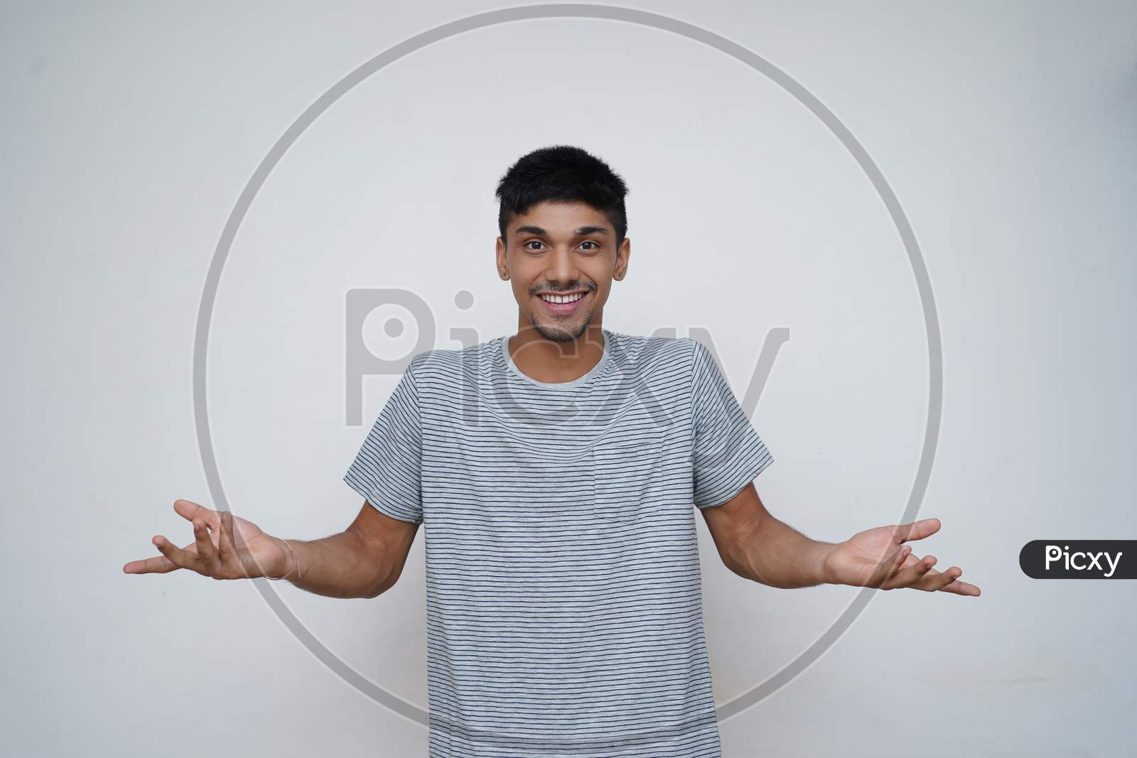 Young Asian Teen Boy Confused Expression With A Smile Showing To The Camera With White Background.
