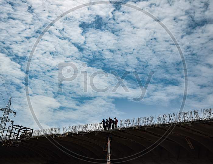 Labourers are seen on the under-construction Kanaka Durga flyover in Vijayawada.