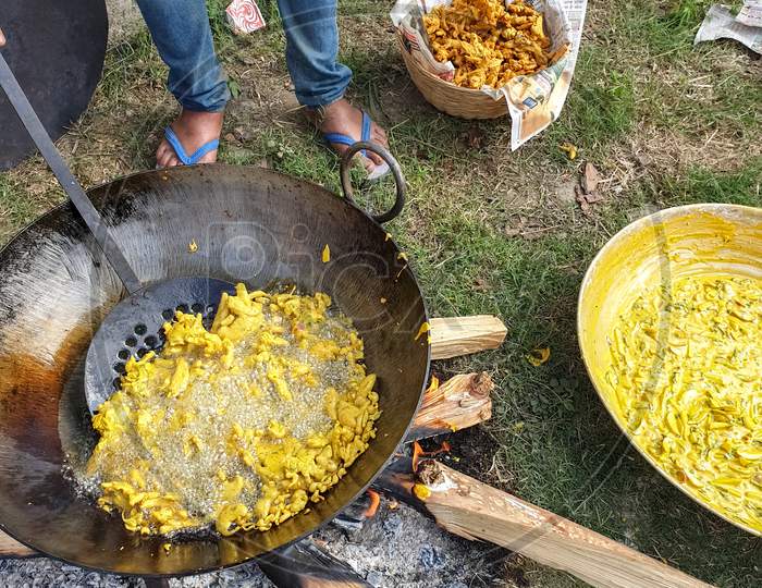 Mandi, Himachal Pradesh / India - June 15 2020: Portrait of Indian people making Indian popular snacks (pakora) in big pan in outdoor during lockdown days, himachal pradesh, India
