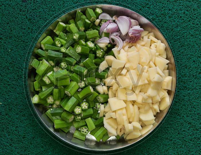 Fresh green ladyfingers potatoes chips and chopped onion