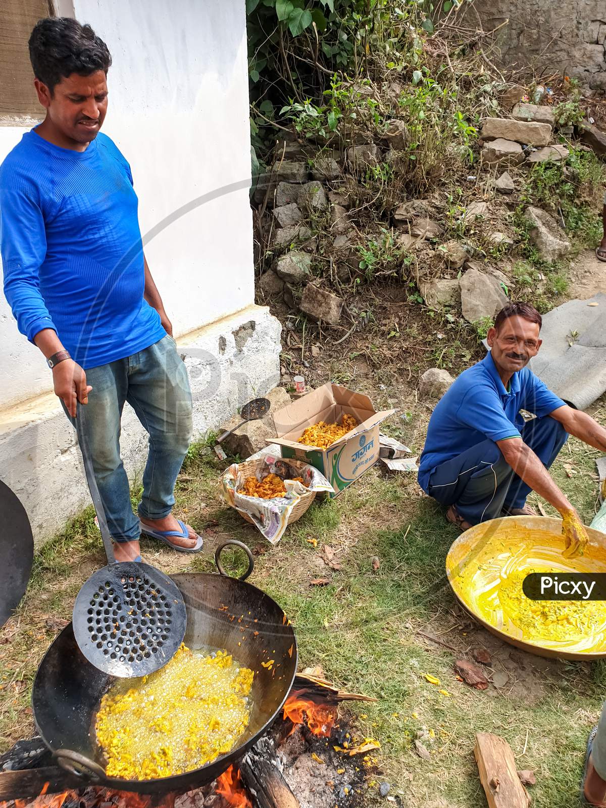 Mandi, Himachal Pradesh / India - June 15 2020: Photo of Indian people making Indian snacks (pakora) in outdoor during lockdown with selective focus, selective focus on subject, background blur