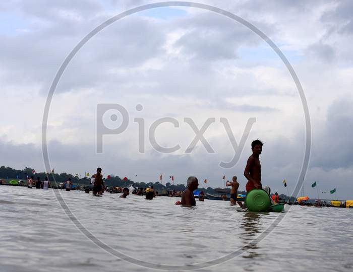 People take a dip in River Ganga which saw an increase in its water level due to heavy rainfall in Prayagraj, Uttar Pradesh on July 07, 2020