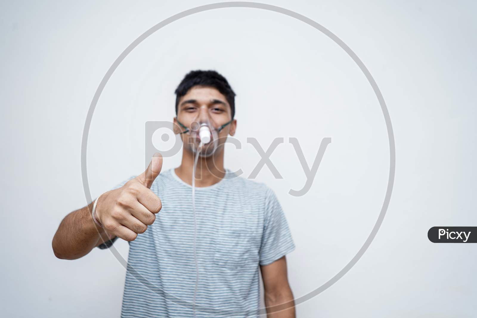 Young Handsome Asian Boy Showing Thumbs Up In The Camera With An Oxygen Mask On His Face.