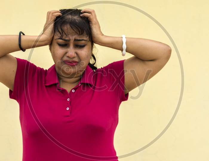 Indian Female Model Looking Straight Frustrated With Slight Angry Face In Yellow Background With Copy Space For Text