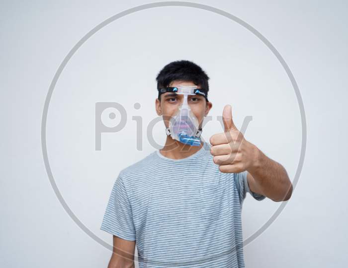 Young Handsome Asian Teen Boy Wearing An Oxygen Mask, Showing Thumbs Up In The Camera.Stop Corona Virus And Stop Pollution Concept.