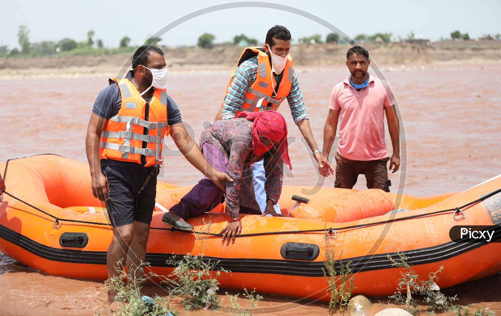 SDRF personnel rescue a woman who was caught in the Tawi River as water levels rose due to heavy rainfall on July 08, 2020 in Jammu