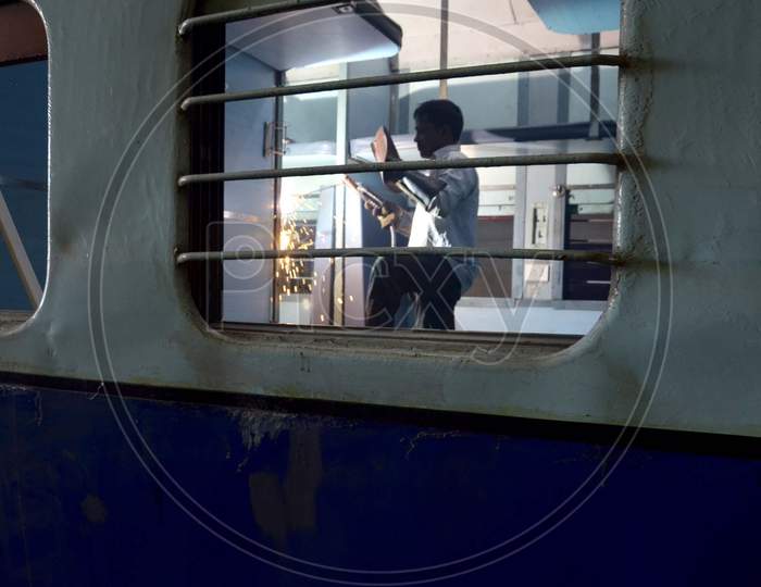 An Indian railway employee works to convert a train coach into an isolation for COVID-19 patients