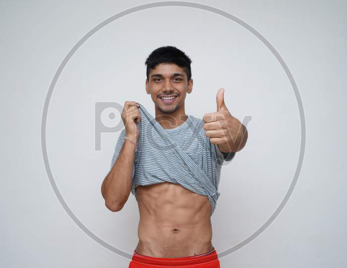 Young Asian Handsome Boy Showing Off His Shredded Abs And Smiling In The Camera, Fitness Concept.