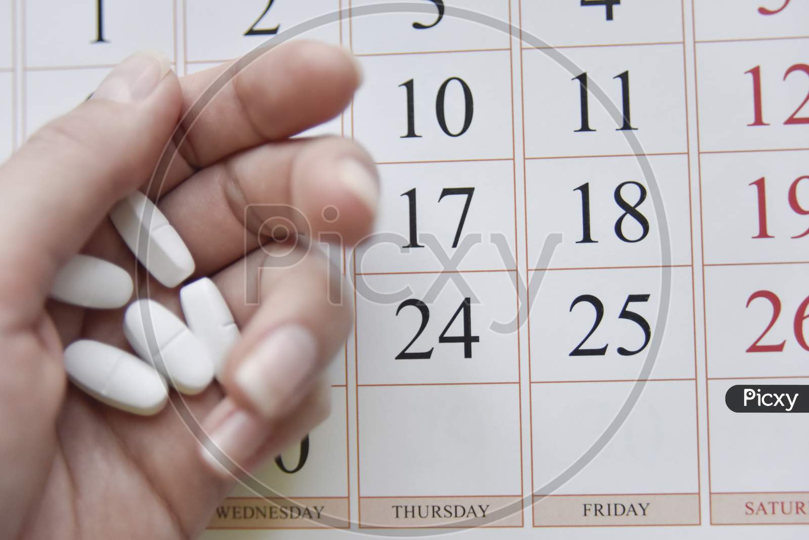 Selective Focus At Pills And Calendar With Blurry Hand