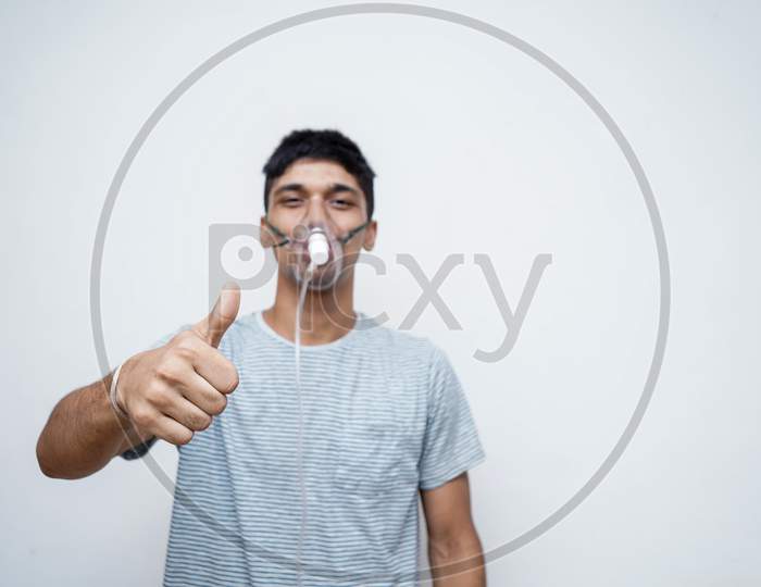 Young Handsome Asian Boy Showing Thumbs Up In The Camera With An Oxygen Mask On His Face.