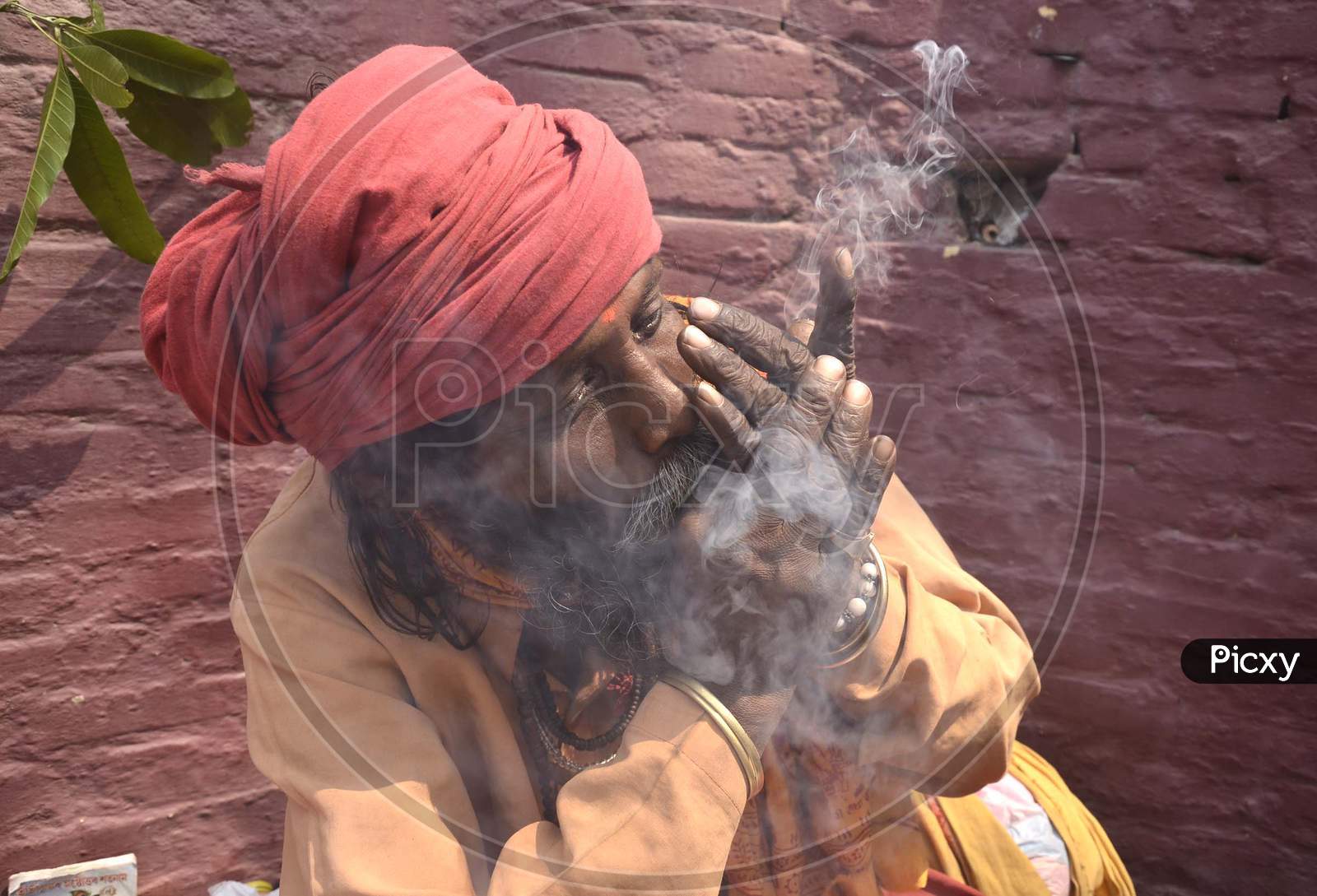 Sadhu smokes cannabis with a chillum