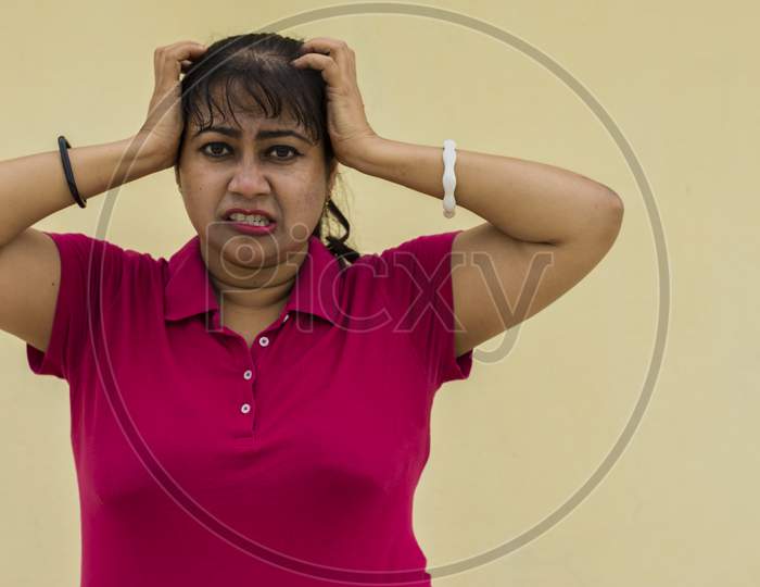 Indian Female Model Looking Straight Frustrated With Slight Angry Face In Yellow Background With Copy Space For Text.