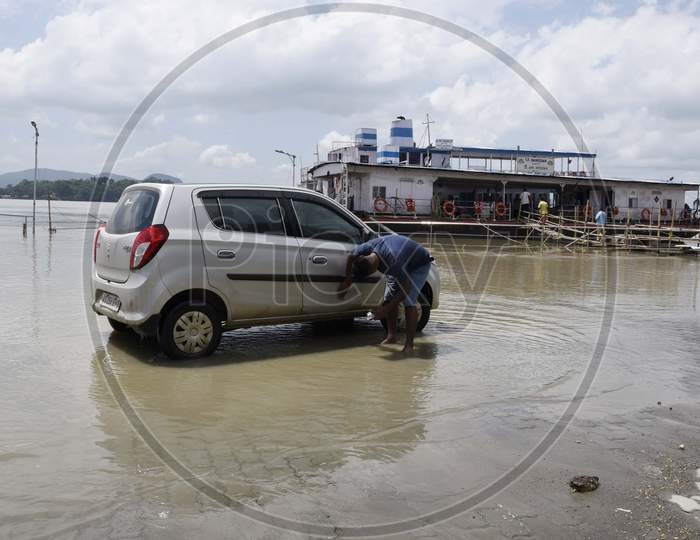 A man washing his car using flood water