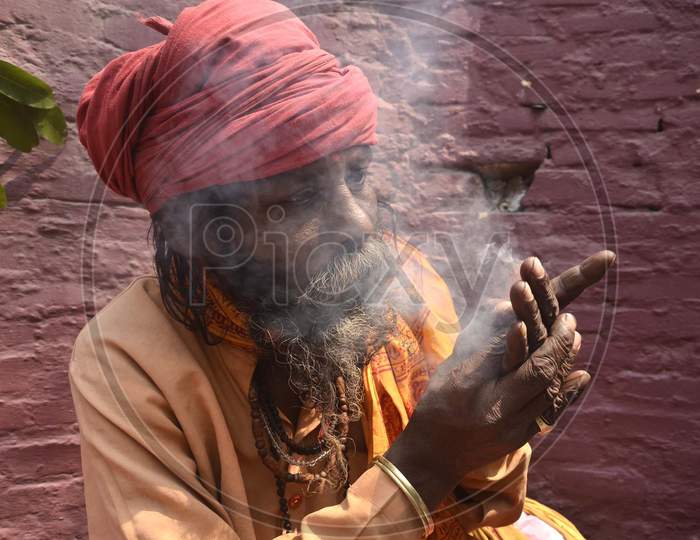 Sadhu smokes cannabis with a chillum