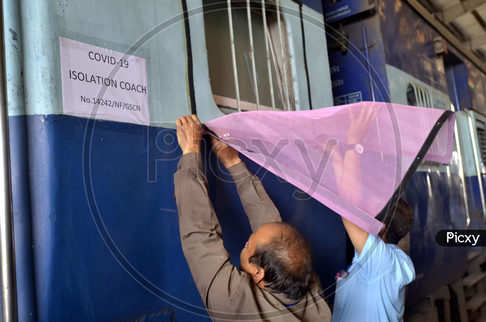 An Indian railway employee works to convert a train coach into an isolation for COVID-19 patients