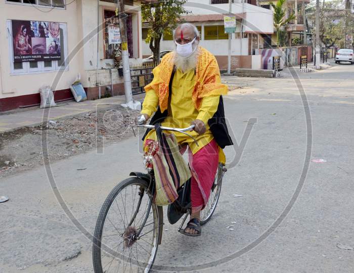 A Sadhu wearing mask riding his by cycle