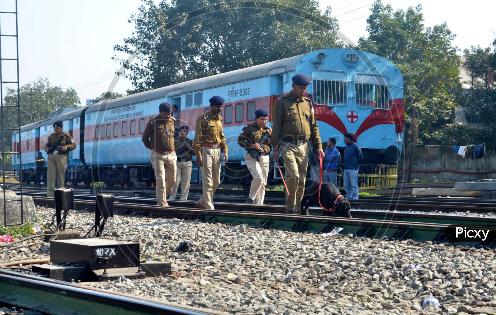 Railway Police Force (RPF) personnel inspect the tracks along with a sniffer dog,