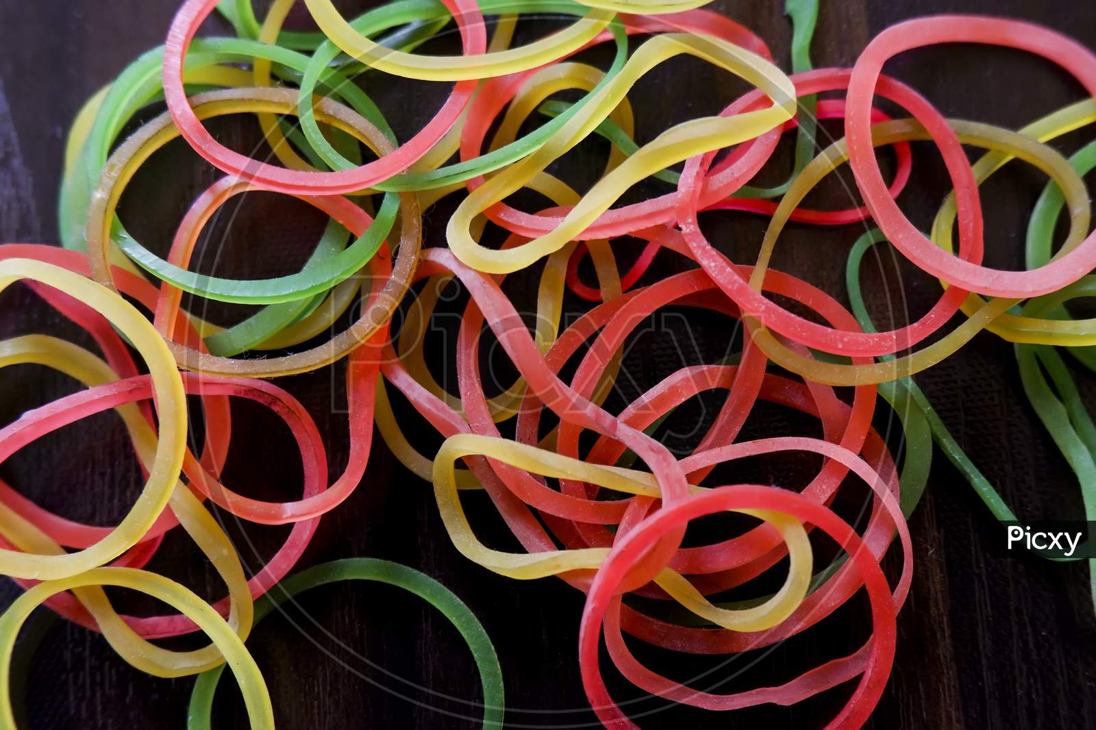 Top View Of Colorful Rubber Bands Isolated On Brown Wooden