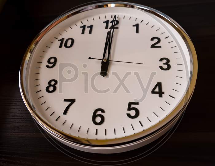 Top View Of Round White Wall Clock Isolated On Wooden Table