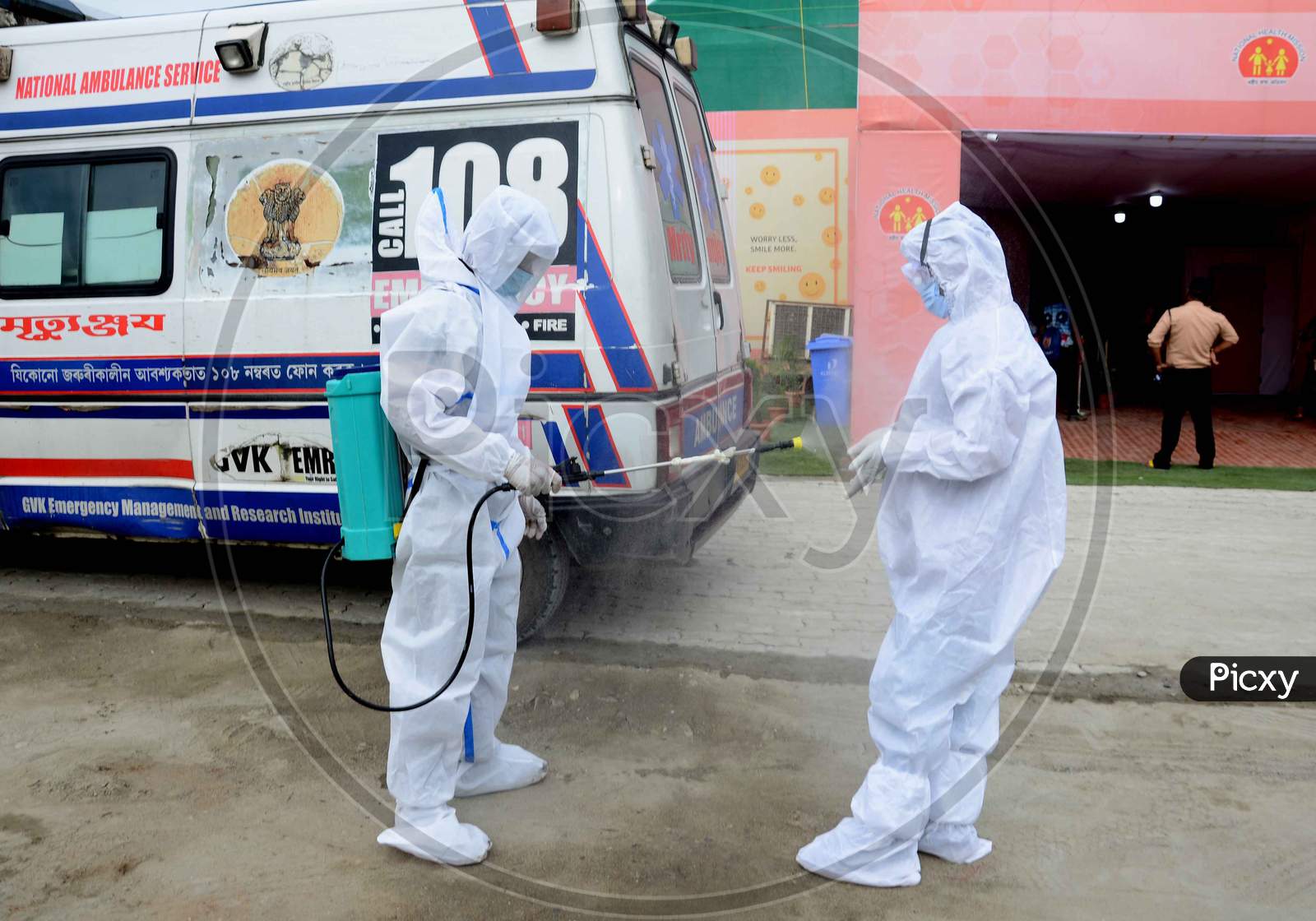 A worker disinfectant spray to an Ambulance driver