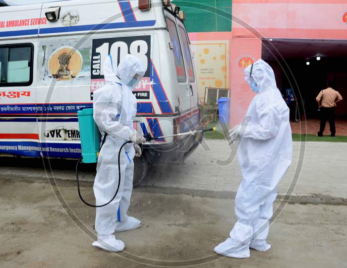 A worker disinfectant spray to an Ambulance driver