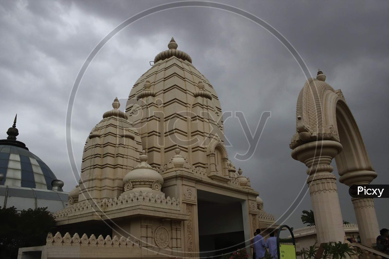 A Hindu Temple Located In Mathura Against Dramatic Black Cloud