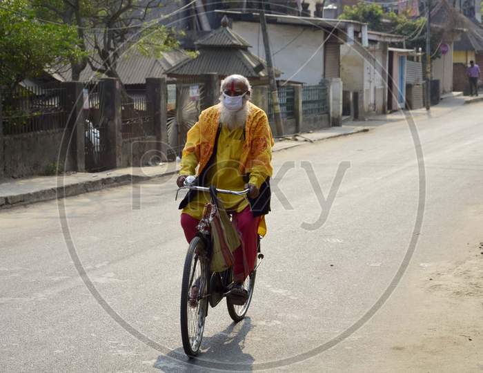 A Sadhu wearing mask riding his by cycle