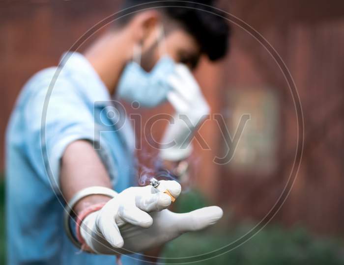 Man Holding Cigarette On His Hand And Feeling Guilty In Pandemic Situation.